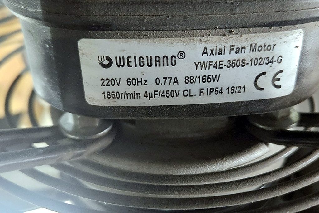 Label on a Weiguang axial fan motor reading YWF4E-350S-102/34-G, 220 volts, 60 hertz, 0.77 amps