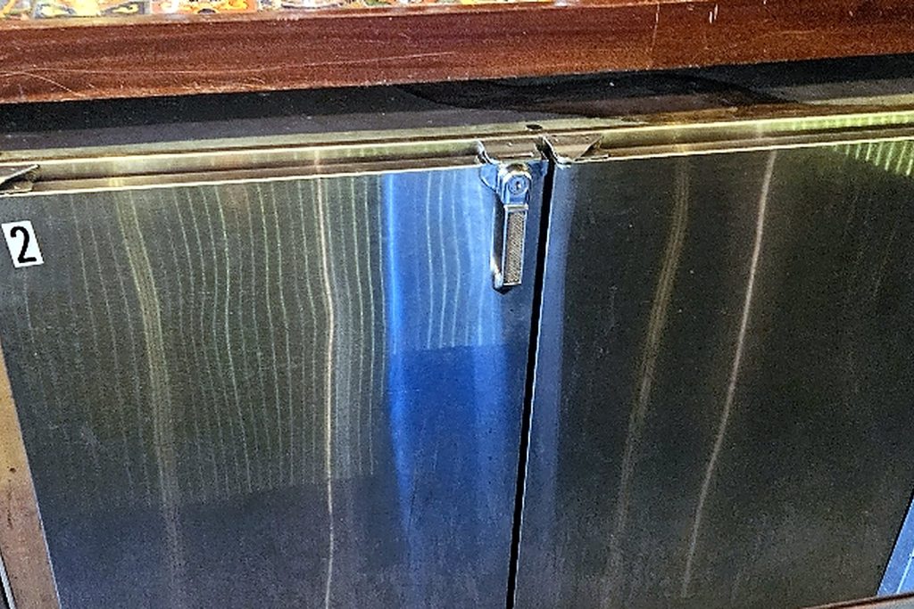 The row of stainless back-bar coolers under the bar top. Unit 2 was the one freezing product.