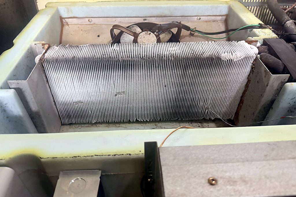 The refrigerator’s condenser coil after cleaning. A coil this clear is a compressor that gets to rest.