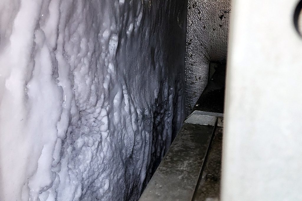 Rooftop unit evaporator coil completely covered in a thick sheet of ice